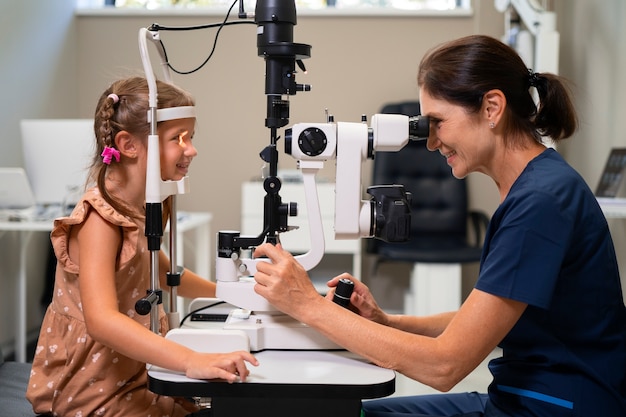 無料写真 オフィスで若い女の子に目の検査を与える女性の眼科
