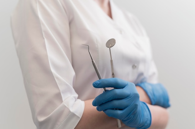 Female orthodontist with latex gloves handling dental equipment