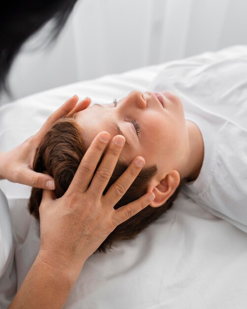 Female osteopathist treating a boy at the hospital