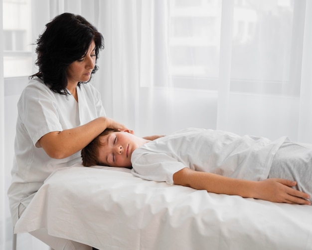 Female osteopathist treating a boy