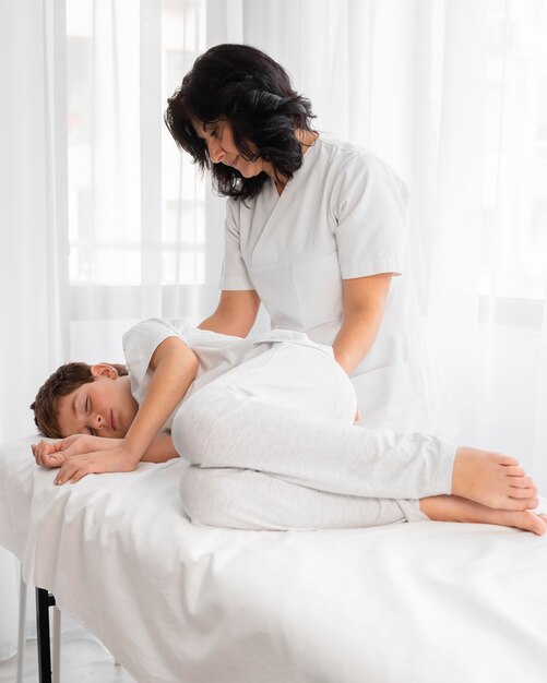 Female osteopathist treating a kid at the hospital