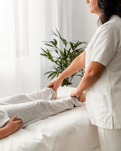 Female osteopathist treating a patient's legs