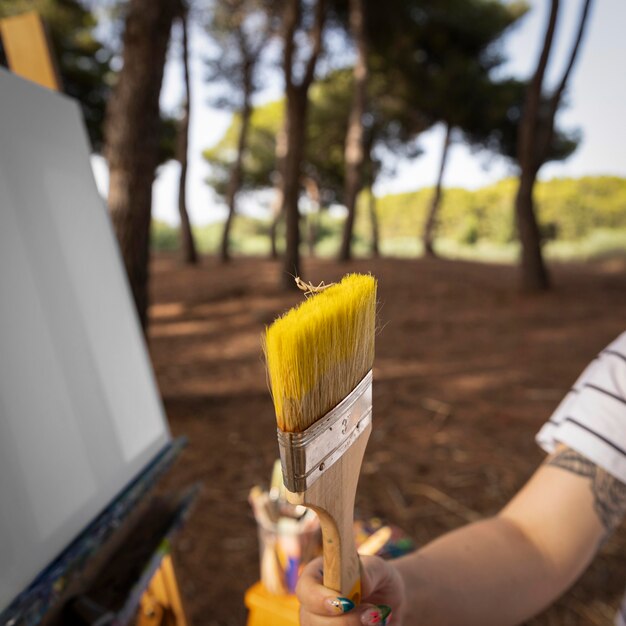 Female painter outdoors holding brush