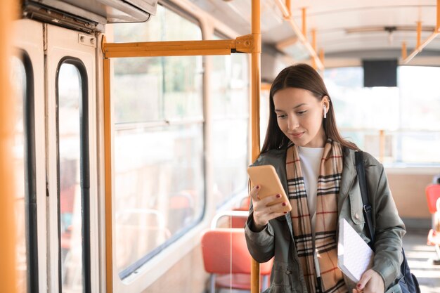 Female passenger leaning on a tram pole