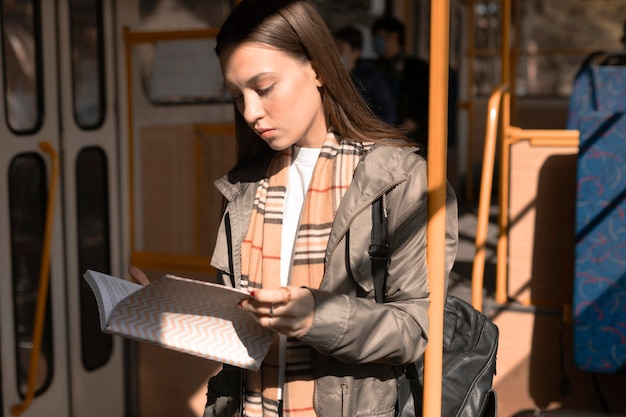 Female passenger reading and travelling by tram