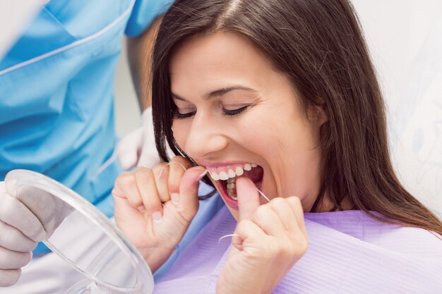 Female patient flossing her teeth