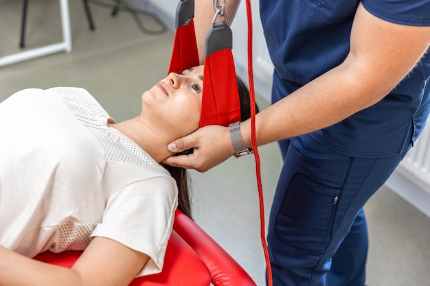 Free photo female patient hanging on suspensions at rehabilitation center