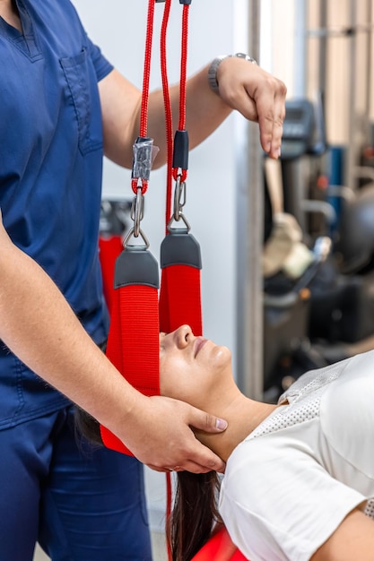 Free photo female patient hanging on suspensions at rehabilitation center