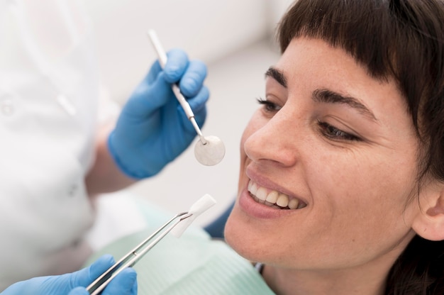 Foto gratuita paziente femminile che ha una procedura eseguita dal dentista