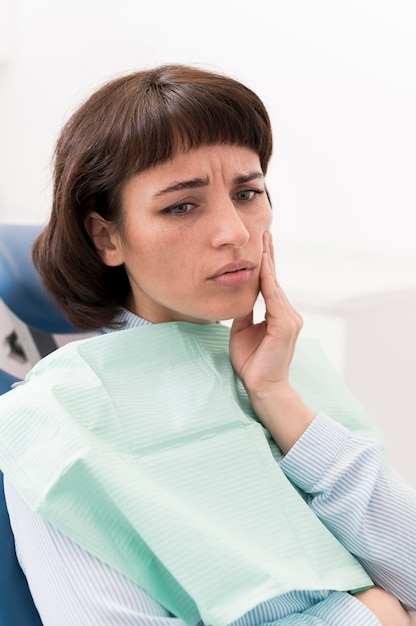 Female patient having a toothache at the dentist's office