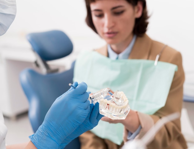 Female patient looking at dental mold with orthodontist