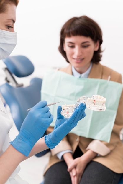 Foto gratuita paziente femminile che esamina lo stampo dentale con l'ortodontista