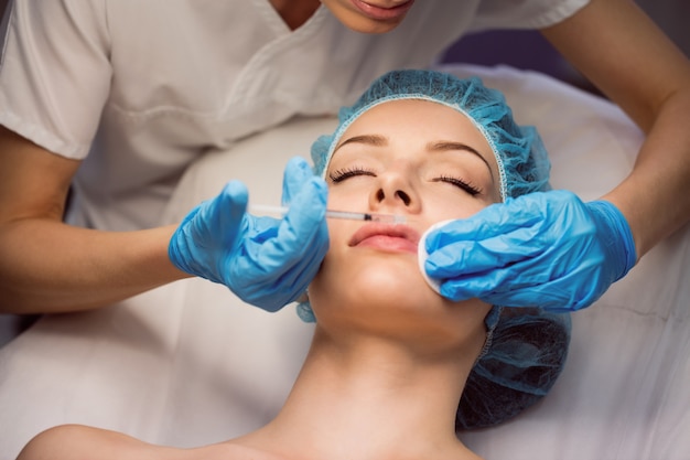 Female patient receiving an injection on her face