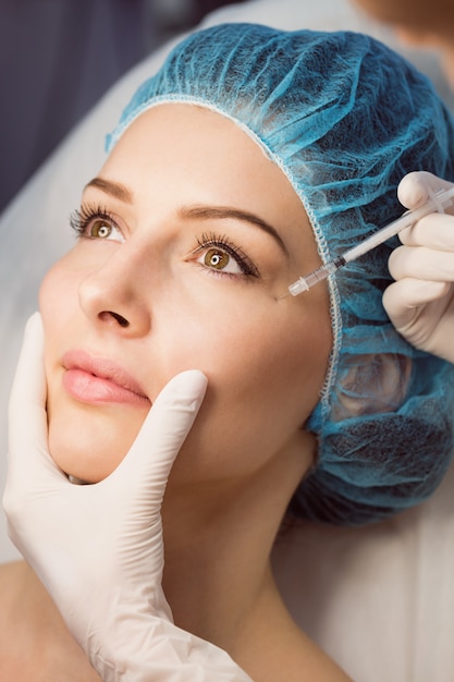 Female patient receiving an injection on her face