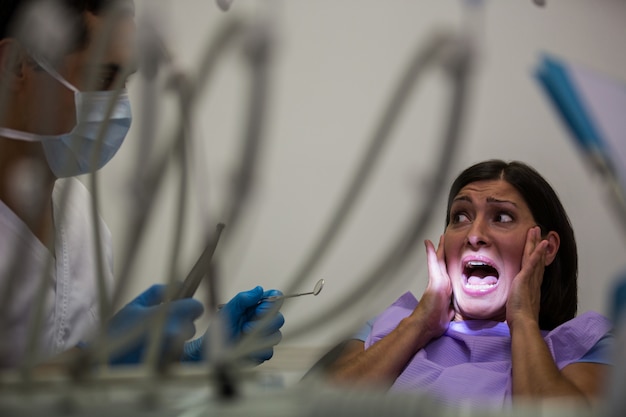 Paziente femminile spaventato durante un controllo dentale