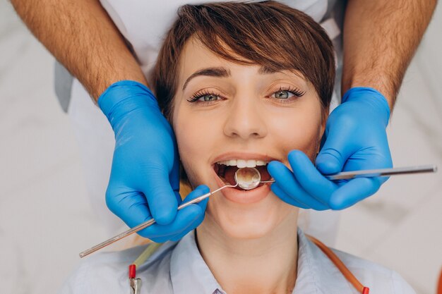 Female patient sitting in a dentist chair and making professinal hygiene