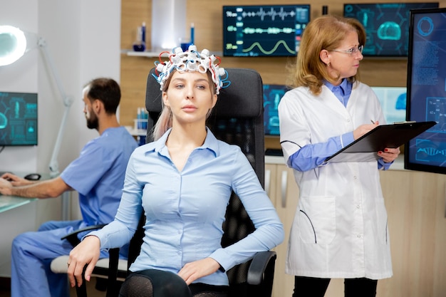뇌파 스캐닝 장치 테스트 중 집중하는 여성 환자. 의사 스캔 뇌