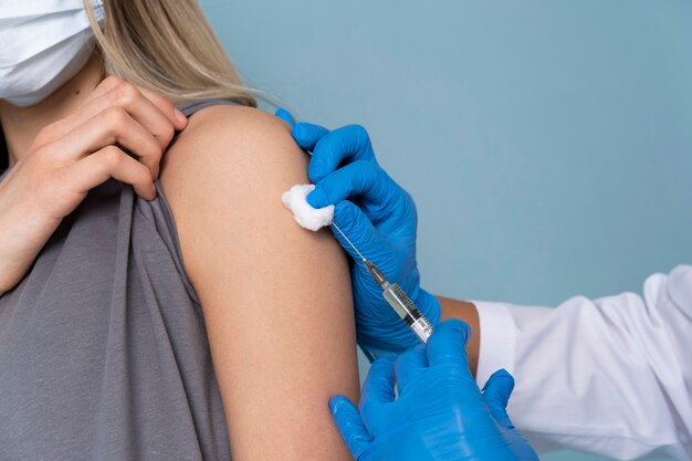 Female patient with medical mask getting a vaccine