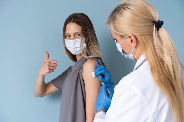 Female patient with medical mask getting a vaccine