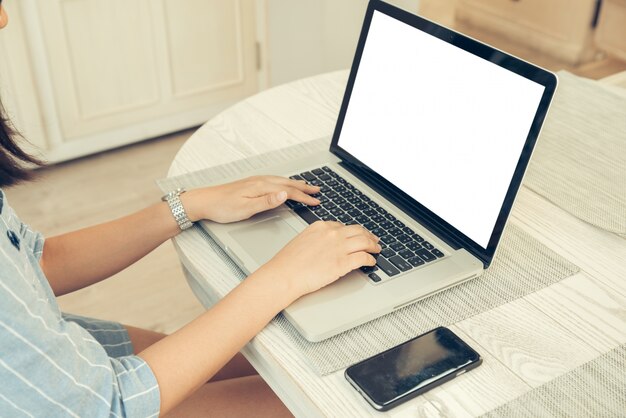 Female person sitting front open laptop computer and smart phone with blank empty screen for your information or content, modern businesswoman work in internet via notebook, student at coffee shop