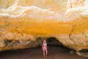 Free photo female person sunbathing on wild rocky beach