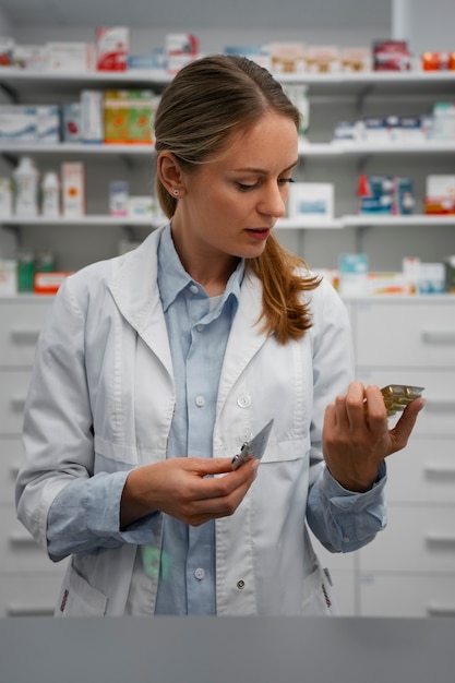 Female pharmacist checking pills in the pharmacy