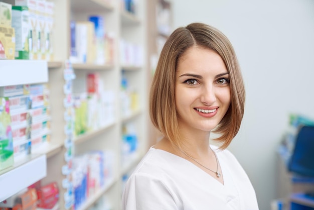 Женщина-фармацевт позирует в аптеке
