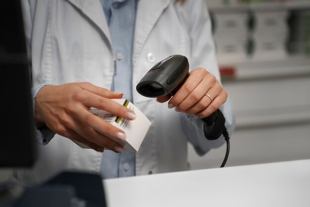 Женщина-фармацевт сканирует лекарства за прилавком