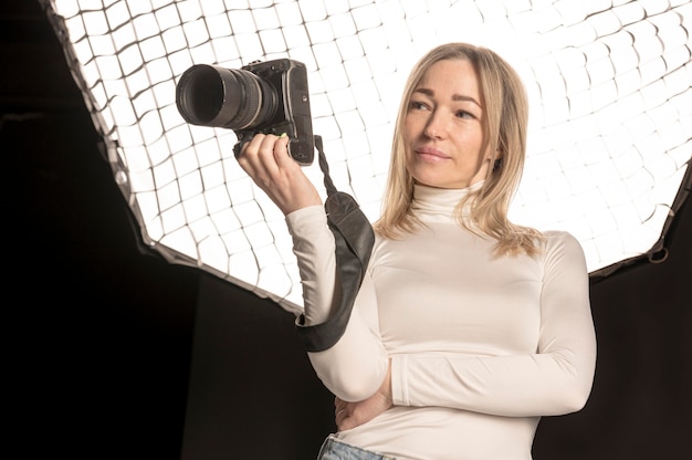 Foto gratuita fotografo femminile che tiene la sua macchina fotografica