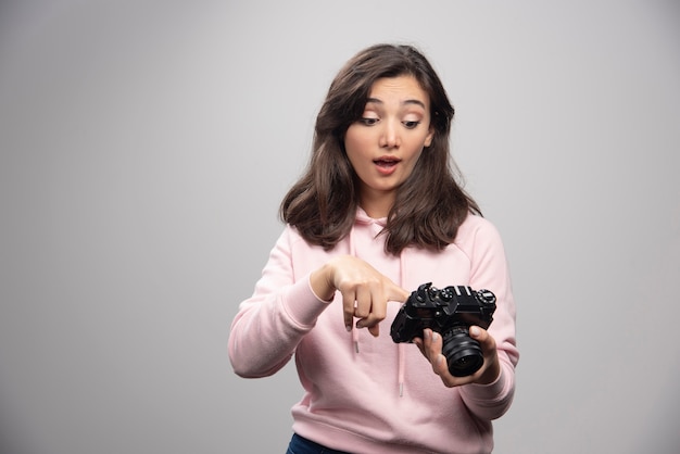 カメラで楽しく写真を見ている女性写真家。