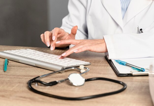 Female physician at her desk writing on keyboard