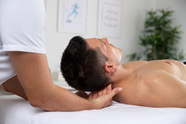 Female physiotherapist massaging male patient in the office