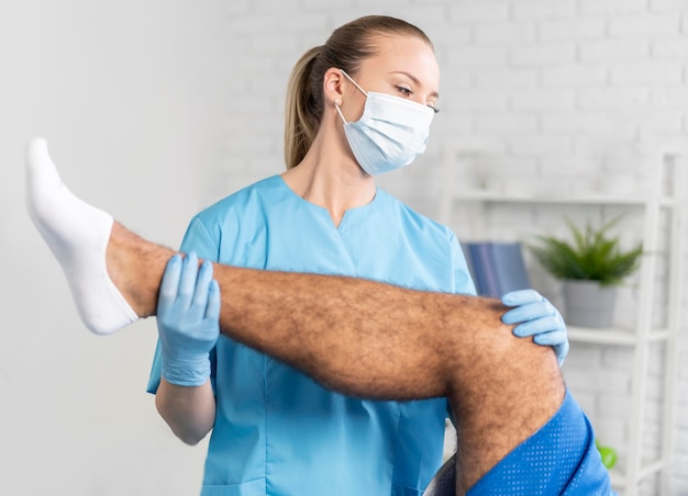 Female physiotherapist with man's leg