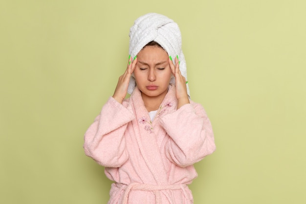 female in pink bathrobe having a severe headache