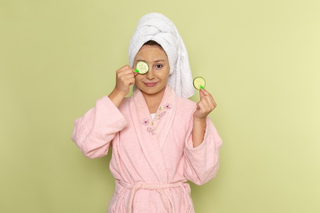 female in pink bathrobe holding cucumber rings