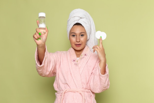 female in pink bathrobe holding spray flask and cottton