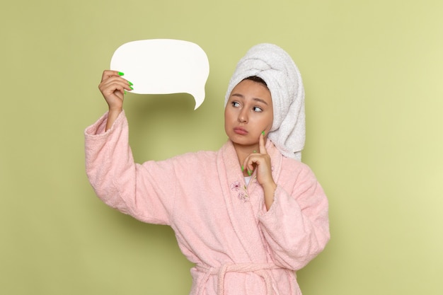 Free photo female in pink bathrobe holding white sign