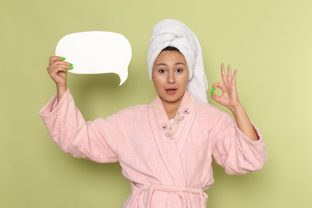 Free photo female in pink bathrobe holding white sign