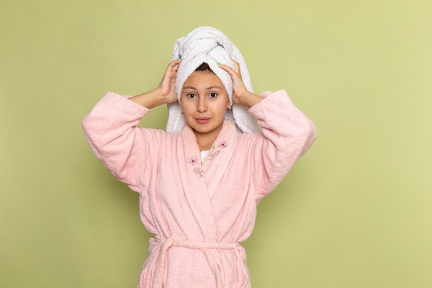 женщина в розовом халате позирует и держит полотенце