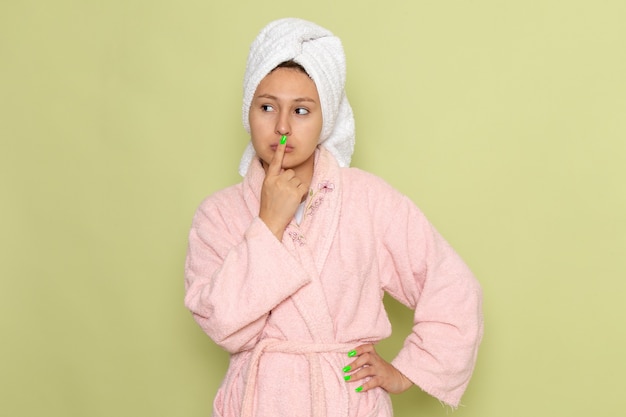 female in pink bathrobe posing with thinking expression