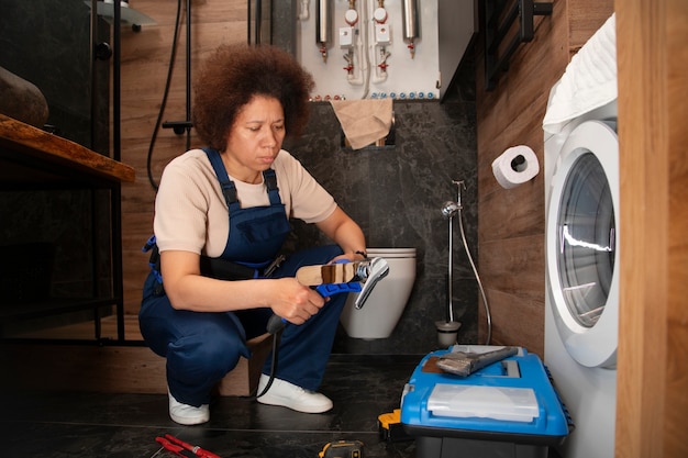 Foto gratuita un'idraulica che lavora per risolvere i problemi a casa di un cliente