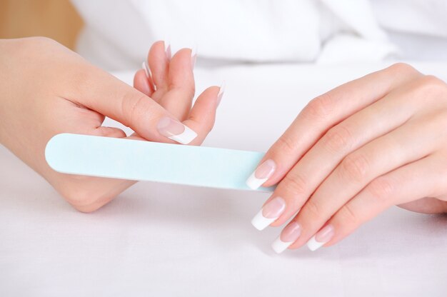 Female polishing  her thumb using the nailfile