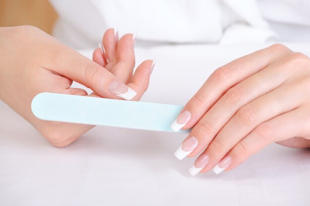 爪やすりを使って親指を磨く女性