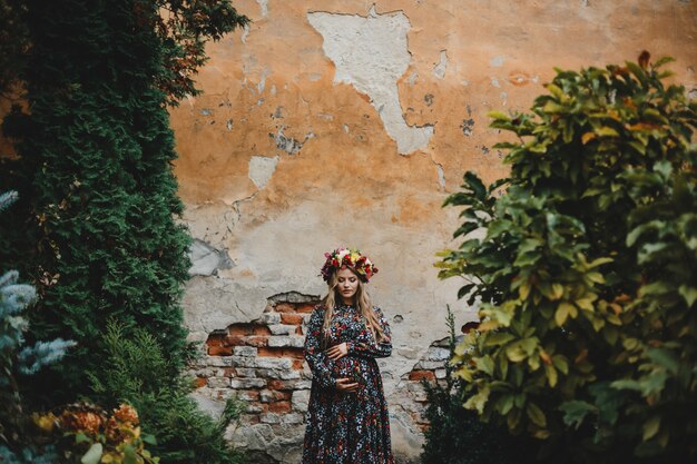 Female portrait. Charming pregnant woman in flower dress poses 