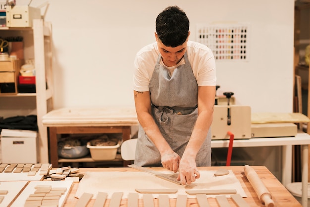 Female potter cutting the clay in rectangular shape