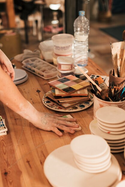 Female potters arranging the ceramic palette on wooden table