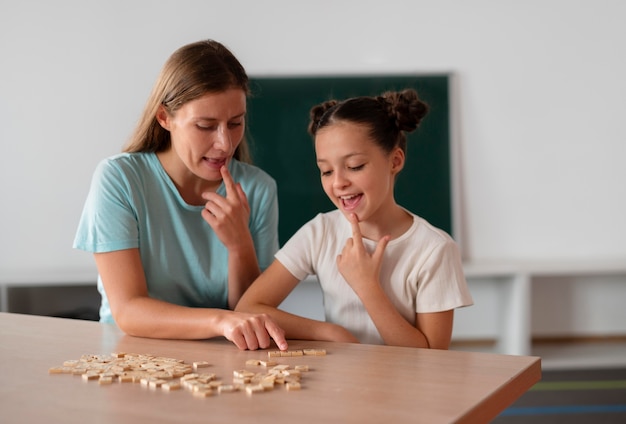 Female psychologist helping a girl in speech therapy