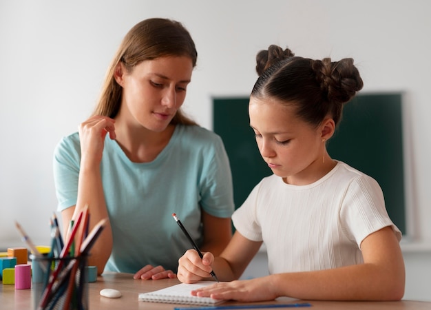 Female psychologist helping a girl in speech therapy