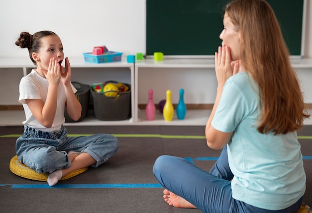 Female psychologist helping a girl in speech therapy