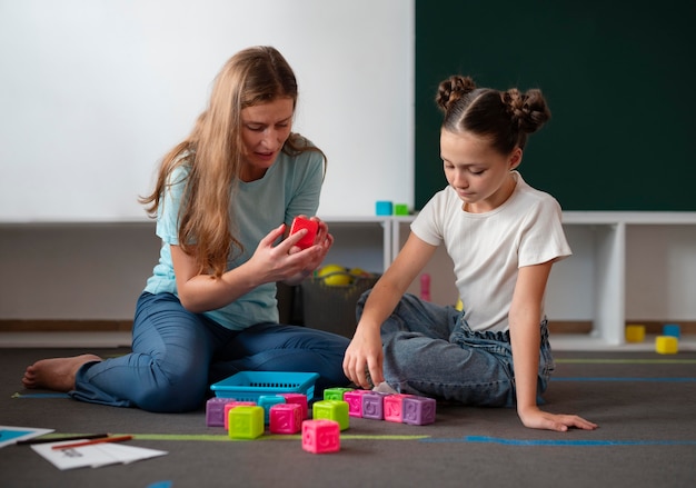 Female psychologist helping a girl in speech therapy